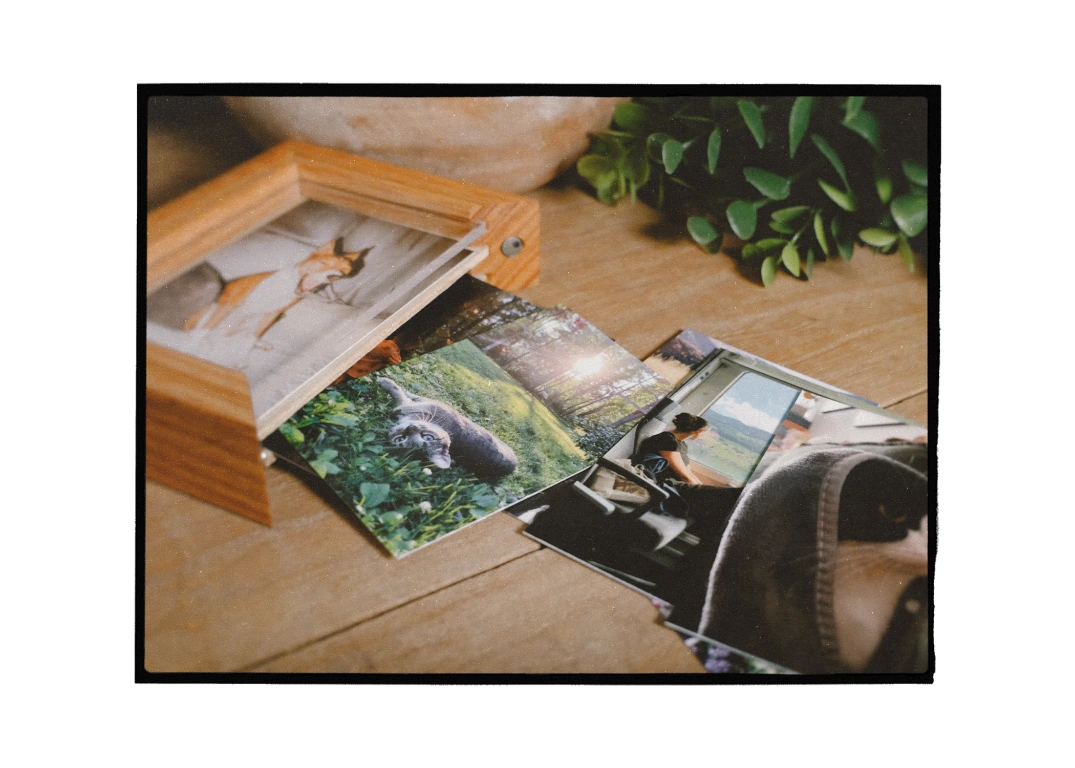 Printed photographs and a wooden photo box on a timber table
